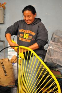 Woman weaving yellow Acapulco Fair Furniture